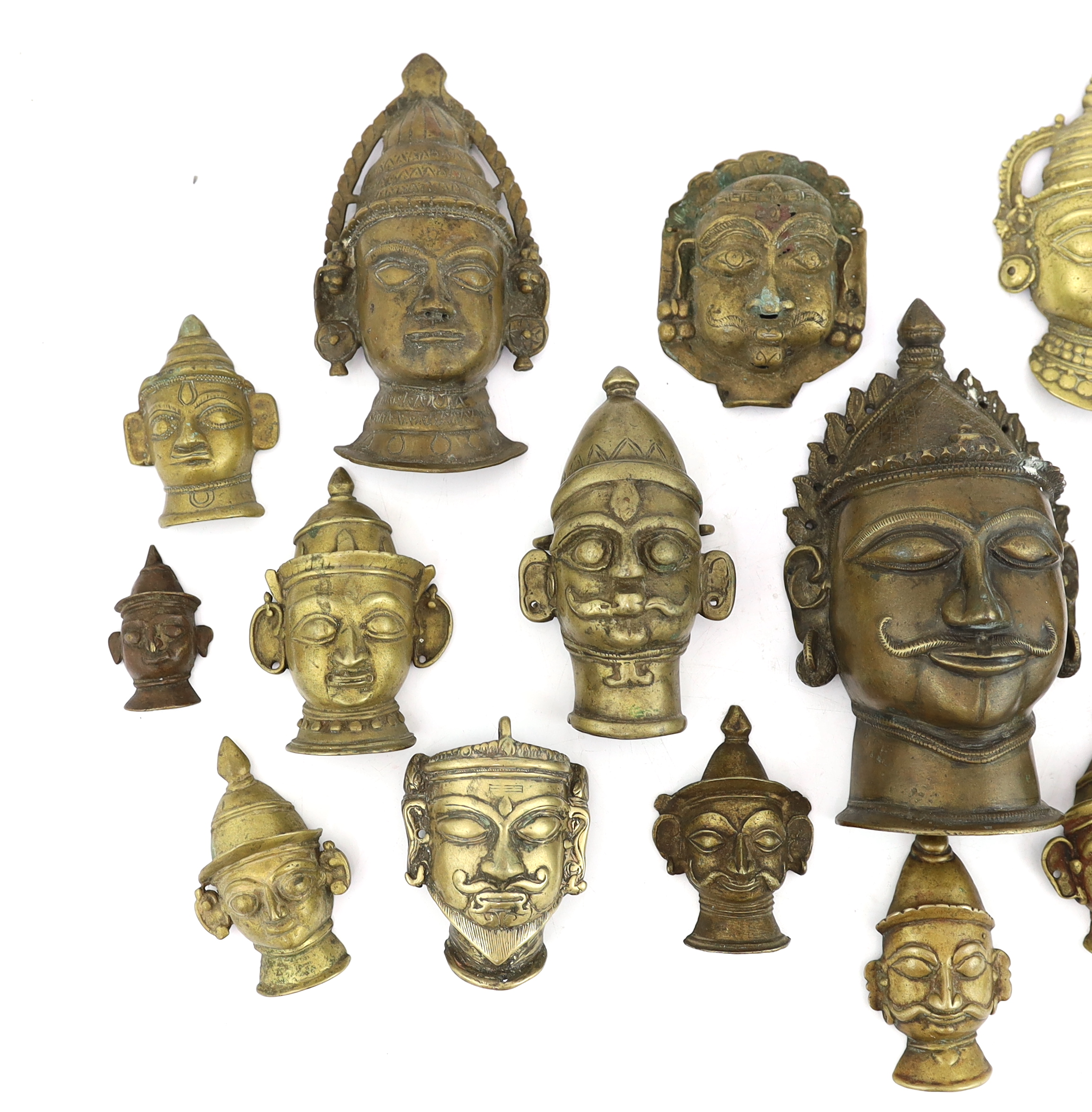 A group of nineteen bronze or brass Shiva masks, Southern India, 16th-19th century, 6.2 - 19.5cm high